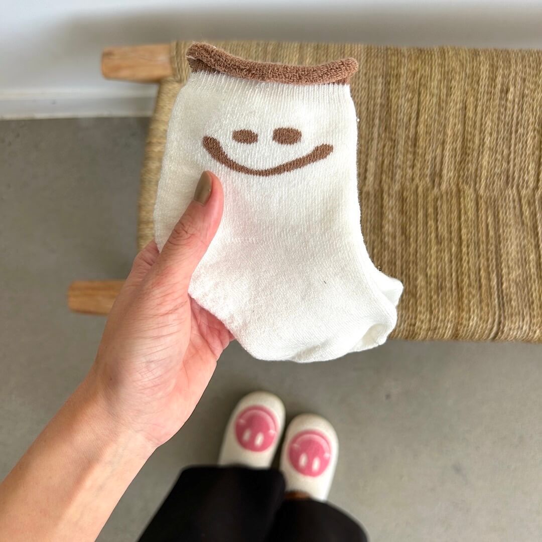 Smiling sock held by hand
