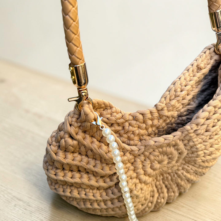 Shell handbag with pearl strap detail and woven construction