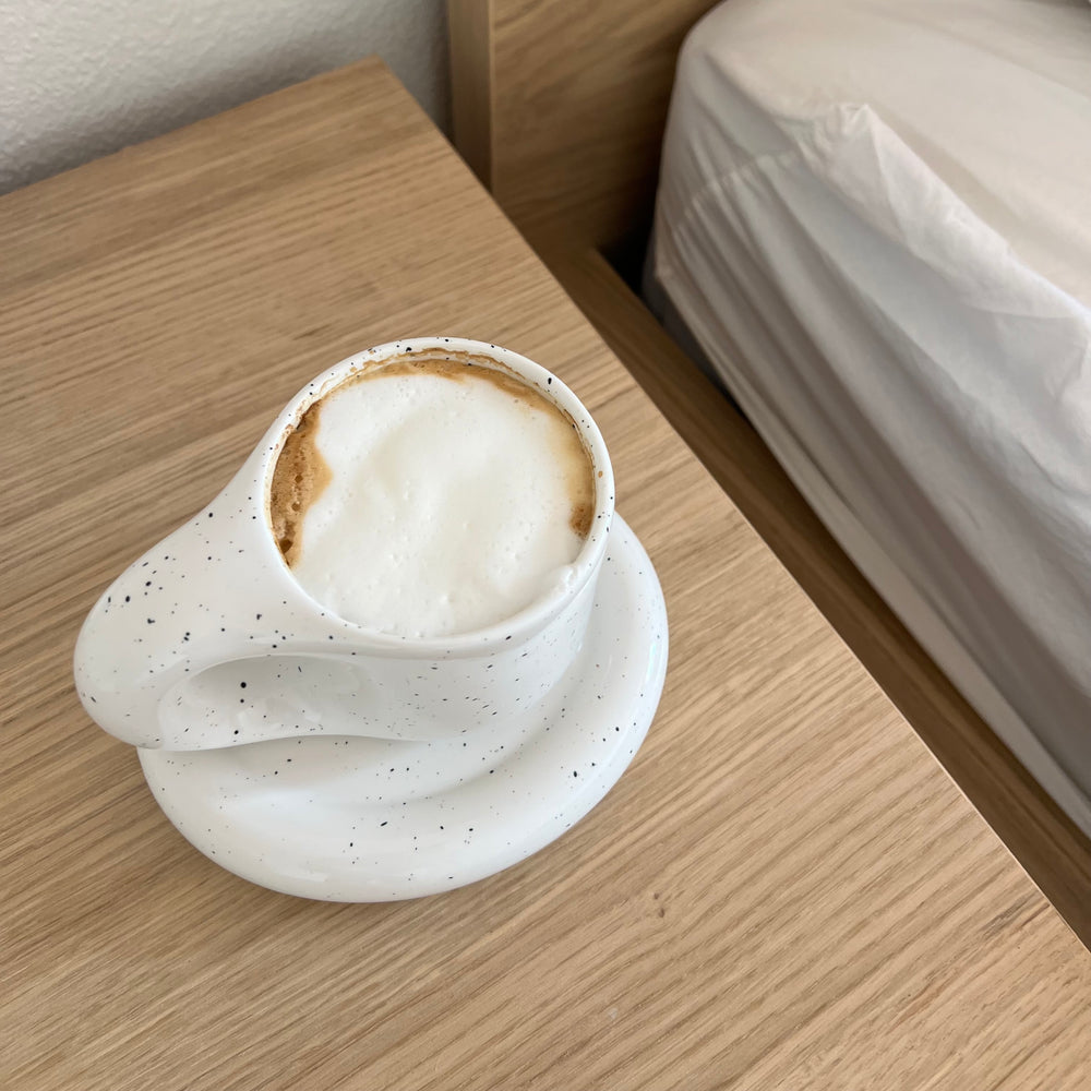 Cup of coffee on a nightstand.