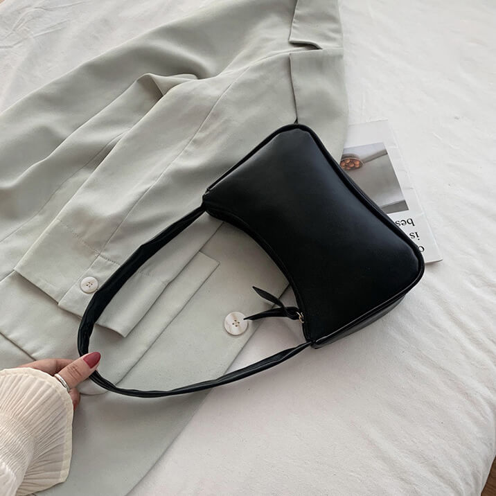 Black shoulder bag on a beige surface