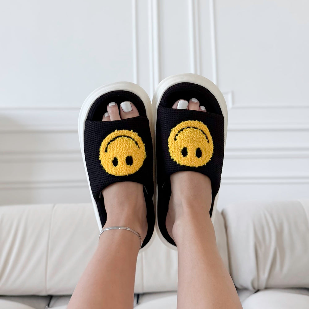 Black platform slides sandals with bold yellow happy face design