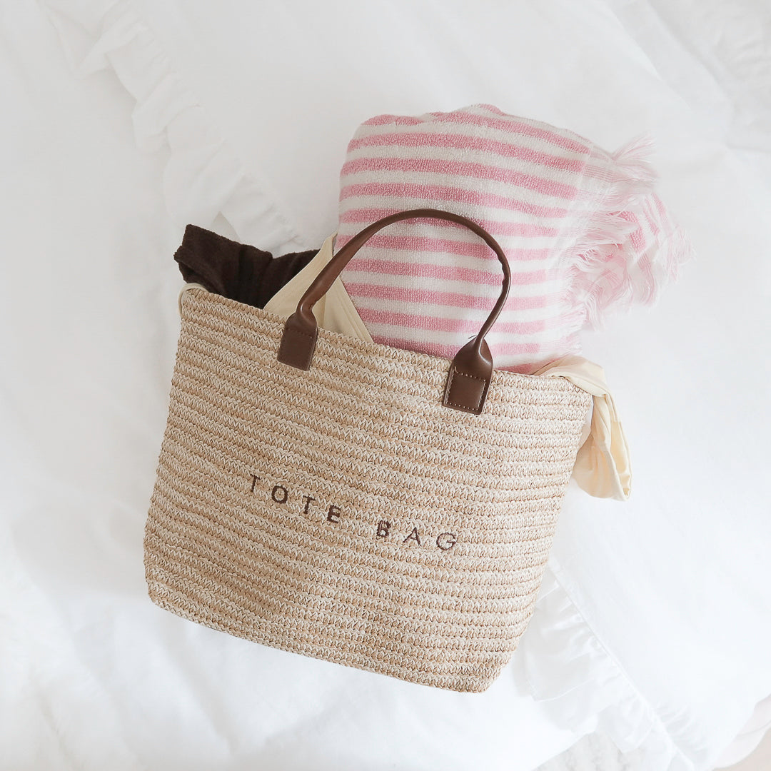 Neutral straw tote bag with brown faux leather handles