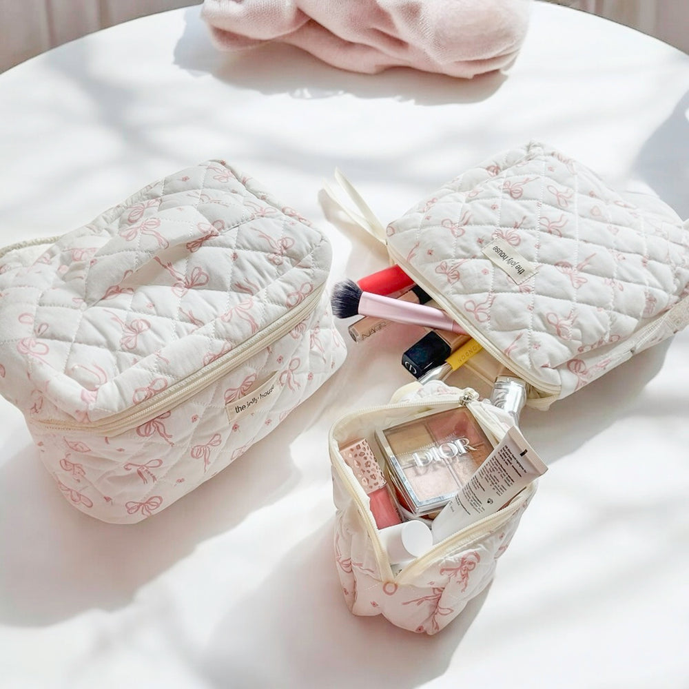 Three piece travel cosmetic bag set with zipper closure and bow design