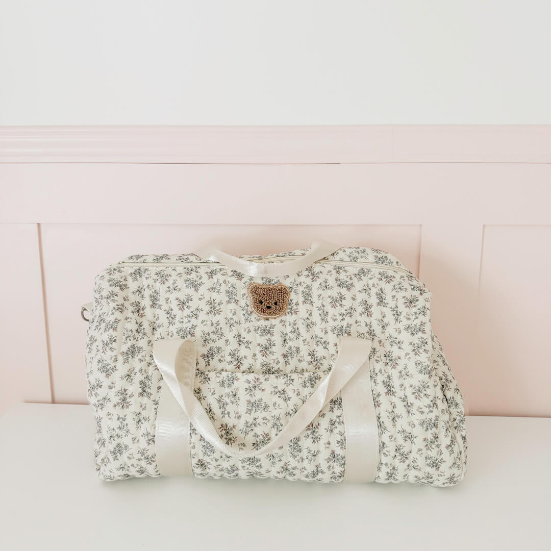 Quilted duffle bag with delicate grey floral print