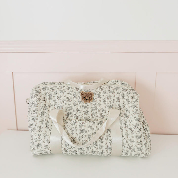Quilted duffle bag with delicate grey floral print