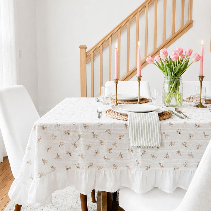 White floral tablecloth with soft pink flowers and green leaves