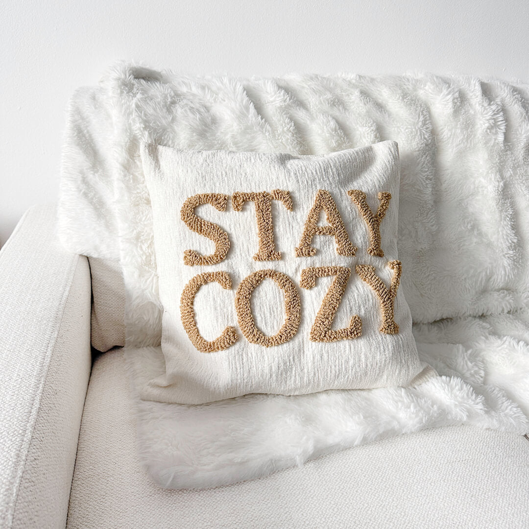 Cream decorative pillow cover with raised Stay Cozy lettering