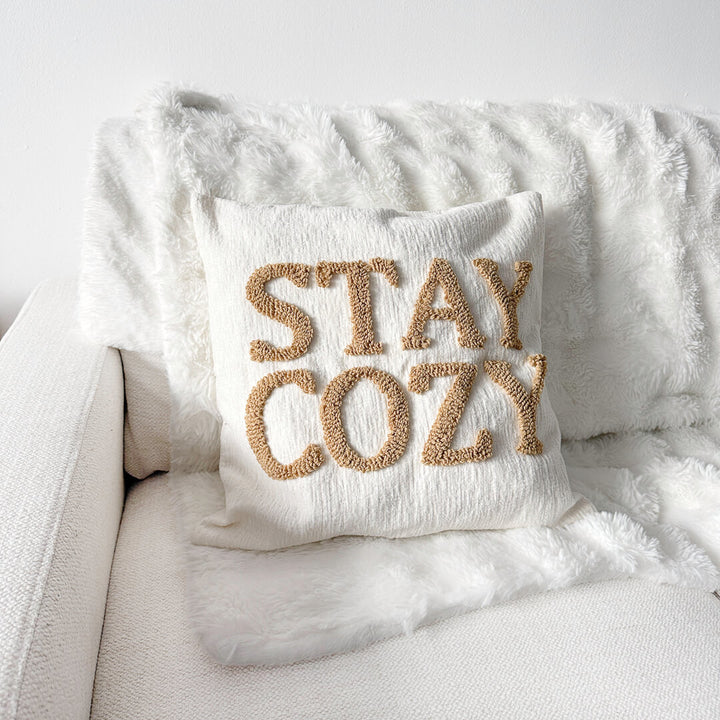 Cream decorative pillow cover with raised Stay Cozy lettering