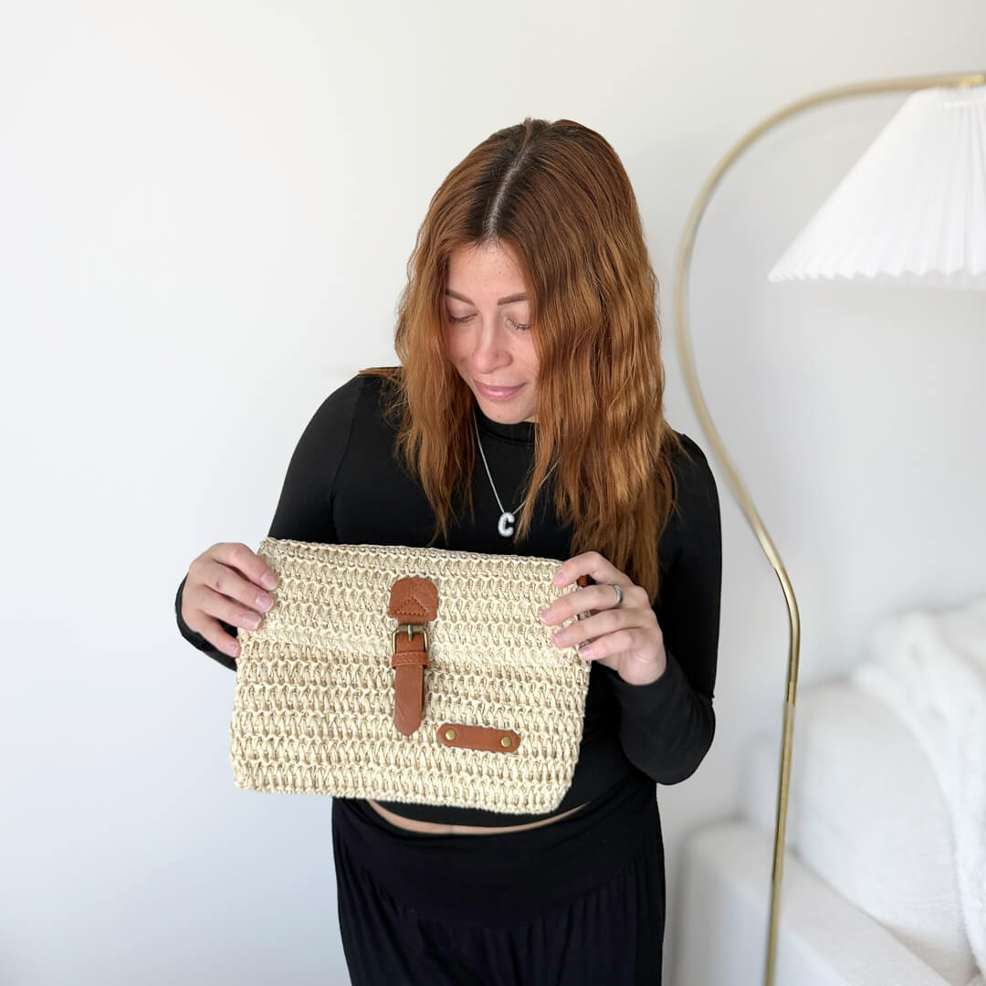 Straw-style crossbody bag with front buckle closure