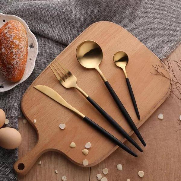 Gold & black flatware set on wooden board